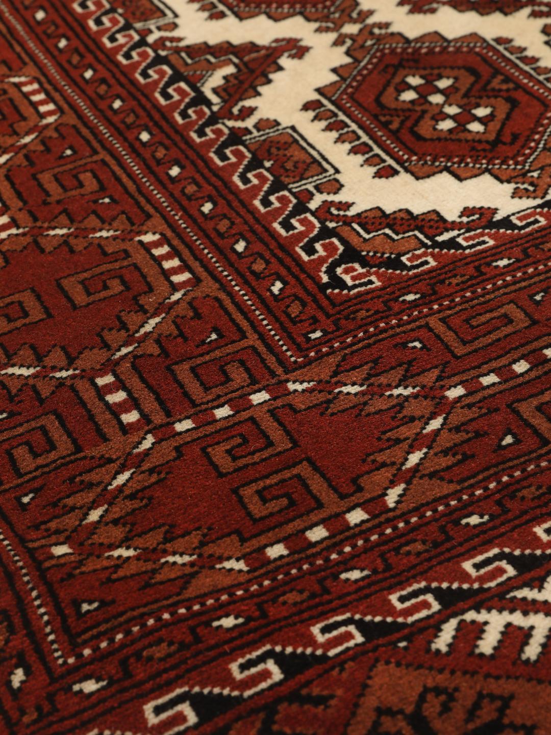 Hand-knotted Turkaman rug from the Middle East in red and cream tones