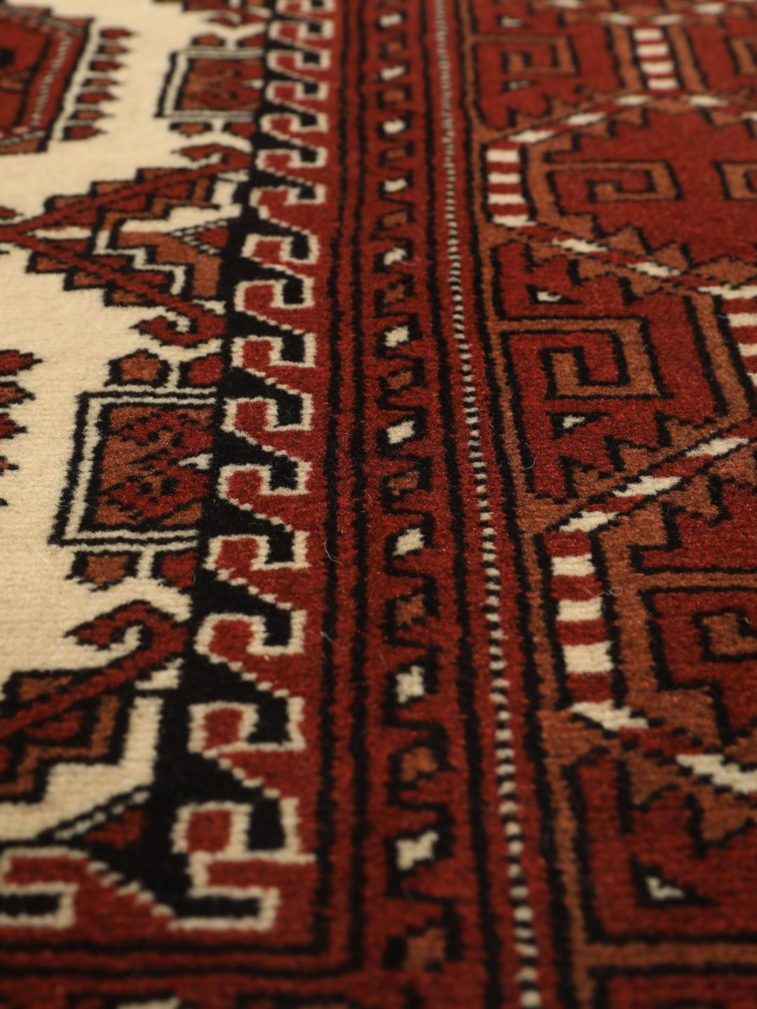 Hand-knotted Turkaman rug from the Middle East in red and cream tones