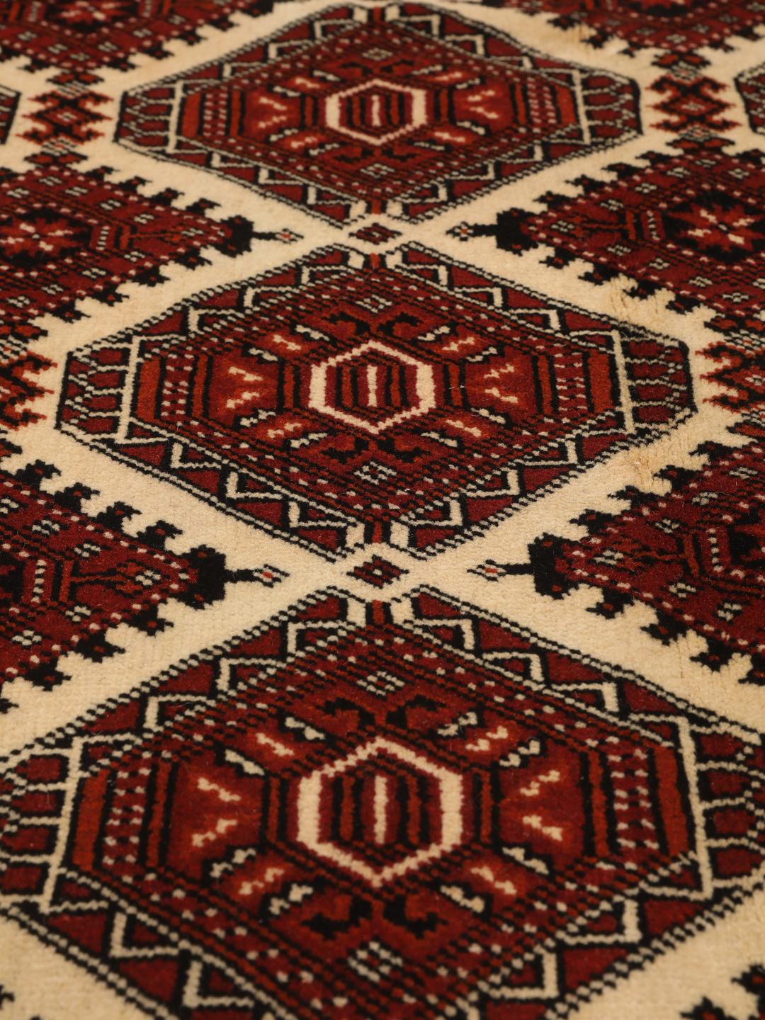 Hand-knotted Turkaman rug from the Middle East in red and black