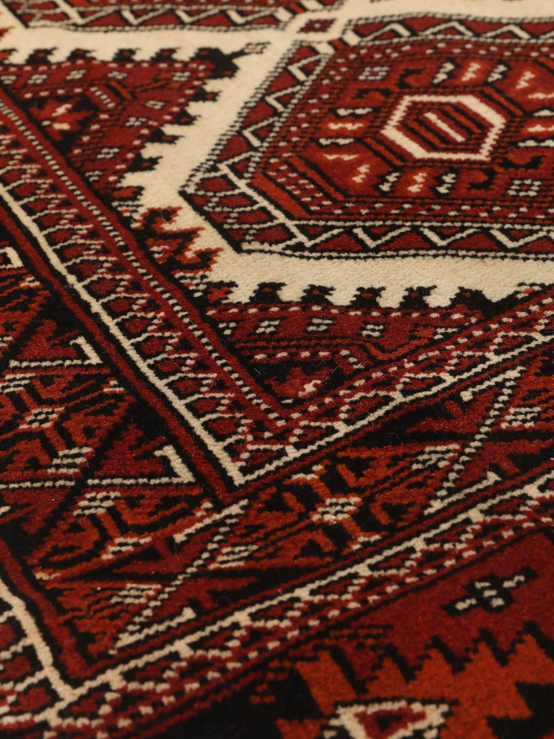 Hand-knotted Turkaman rug from the Middle East in red and black
