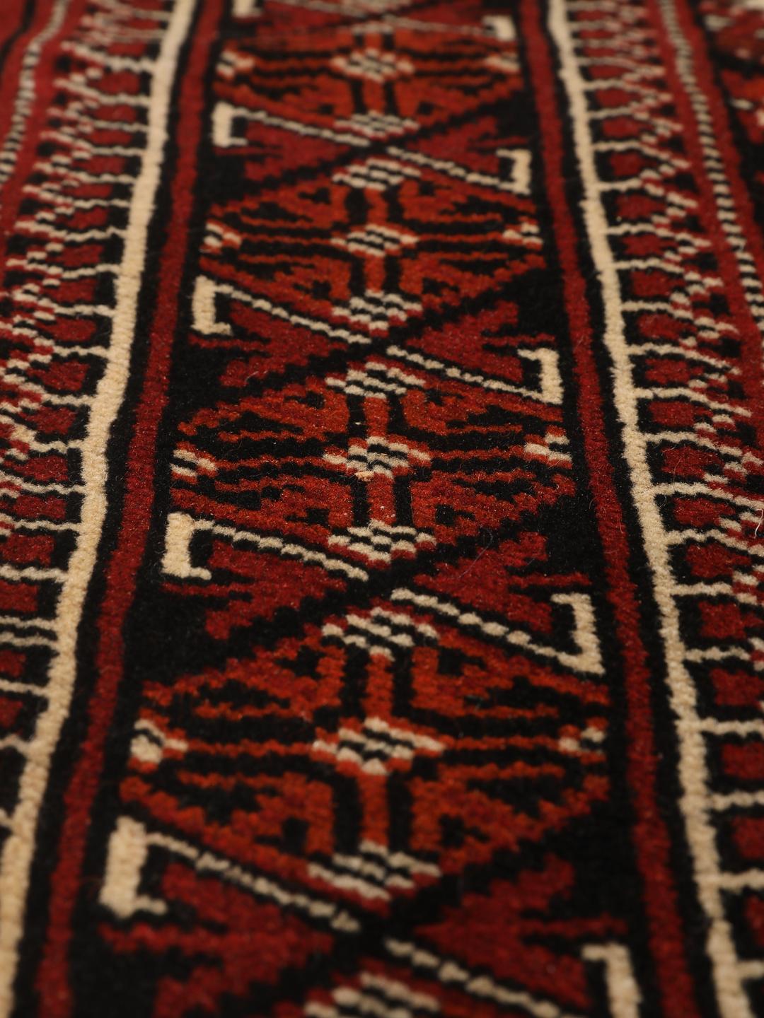 Hand-knotted Turkaman rug from the Middle East in red and black