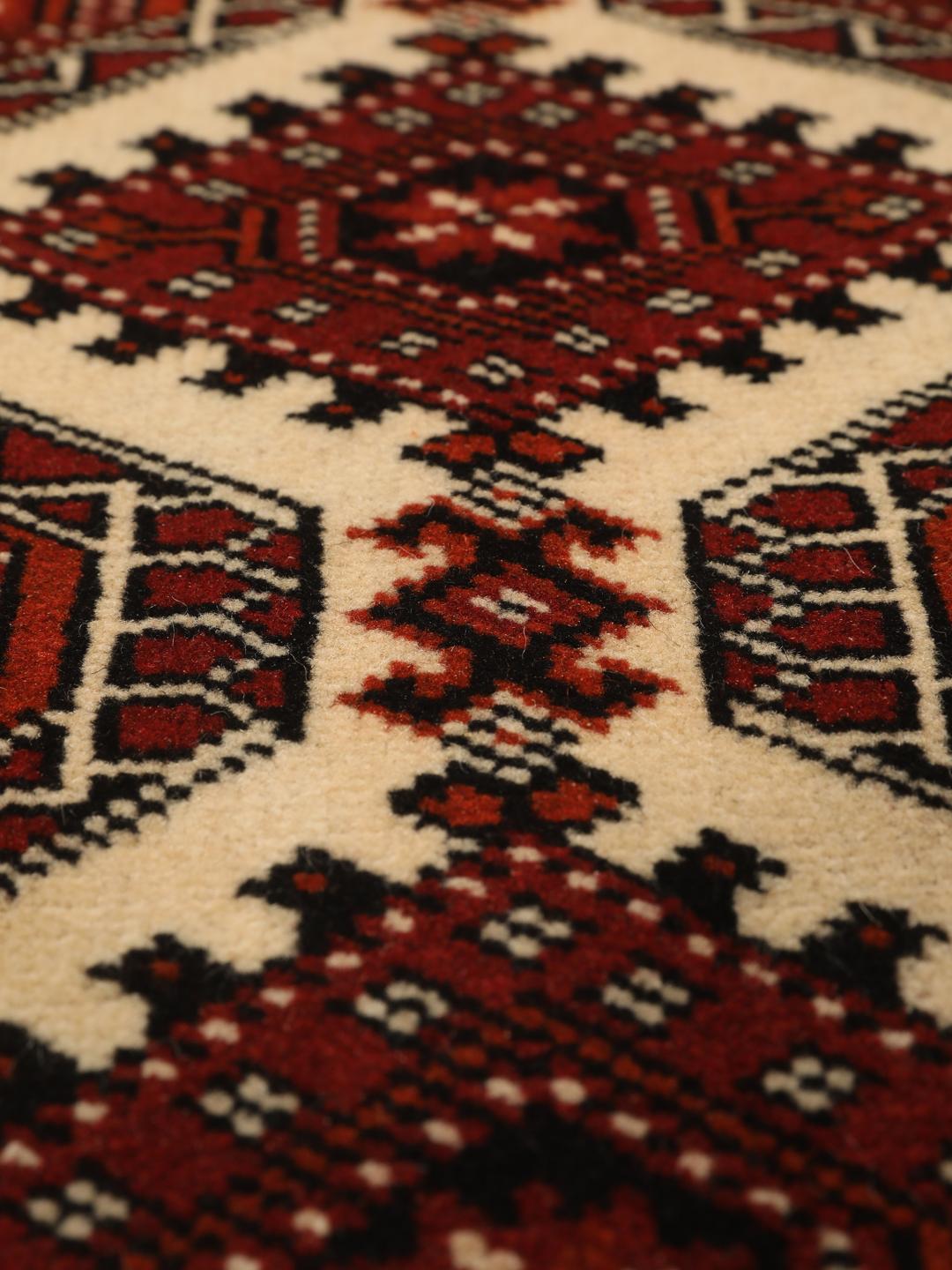Hand-knotted Turkaman rug from the Middle East in red and black