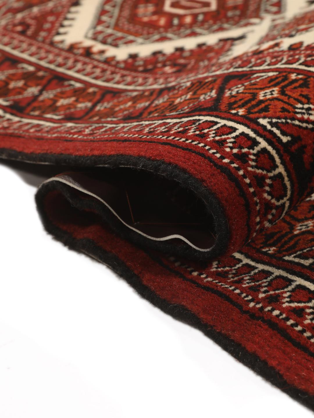 Hand-knotted Turkaman rug from the Middle East in red and black