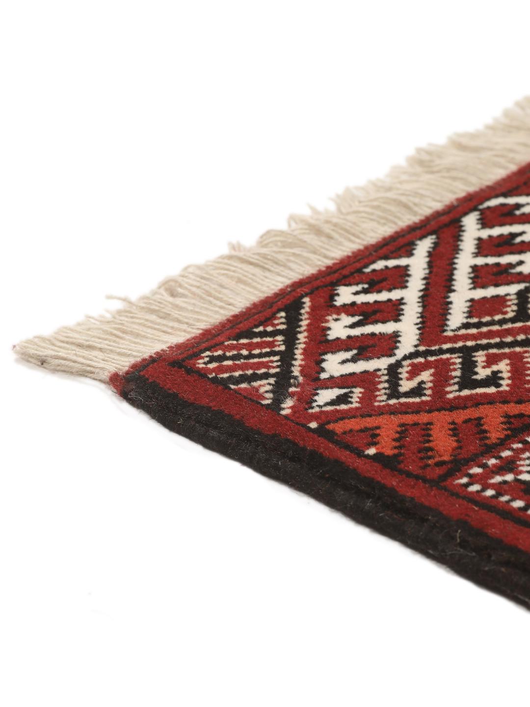 A long, hand-knotted Turkaman runner from the Middle East featuring a vibrant red and cream geometric design.