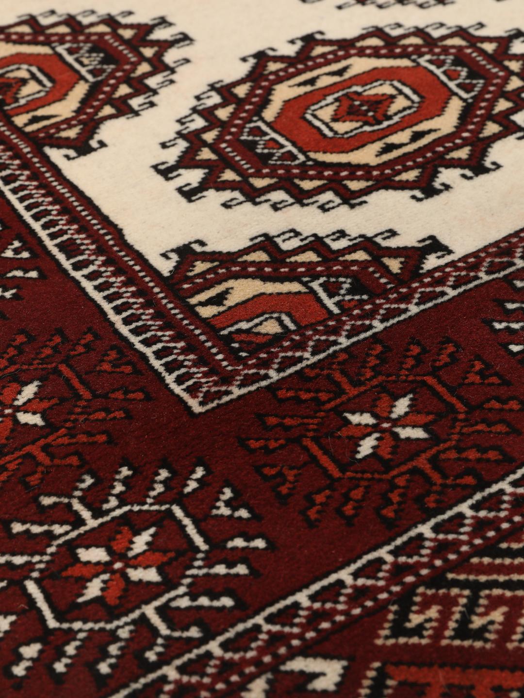 A long, hand-knotted Turkaman runner from the Middle East featuring a vibrant red and cream geometric design.