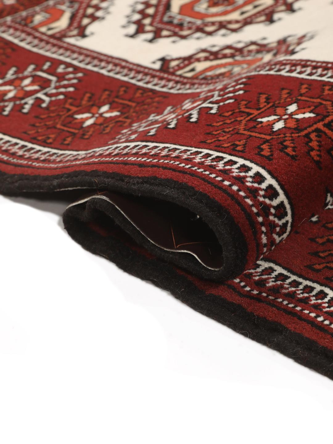 A long, hand-knotted Turkaman runner from the Middle East featuring a vibrant red and cream geometric design.