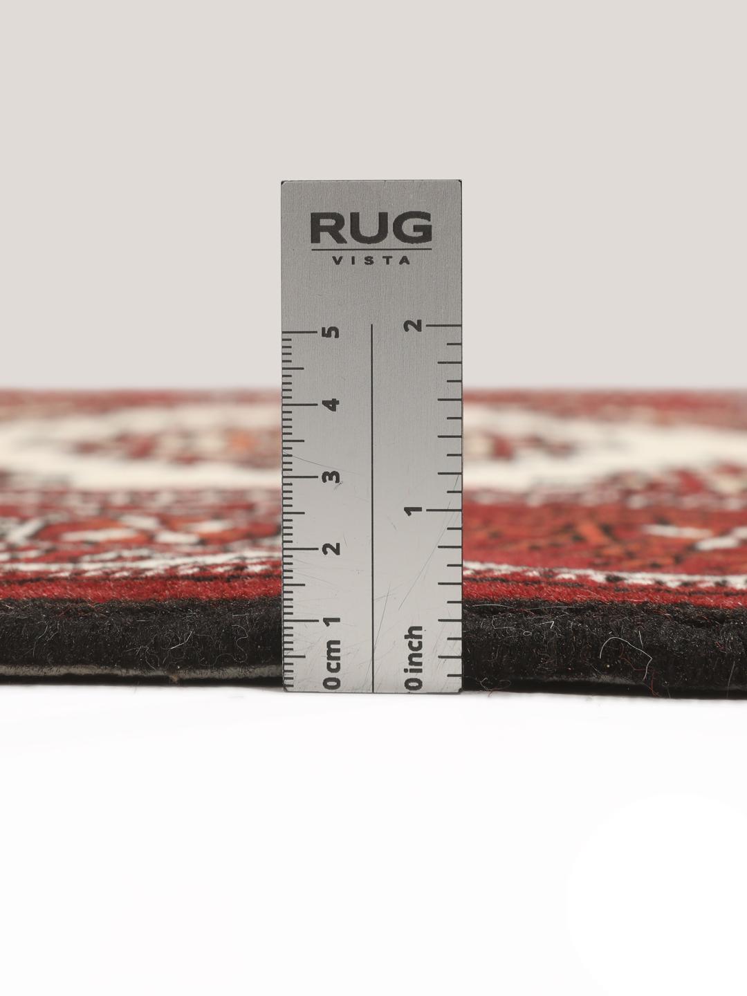 A long, hand-knotted Turkaman runner from the Middle East featuring a vibrant red and cream geometric design.