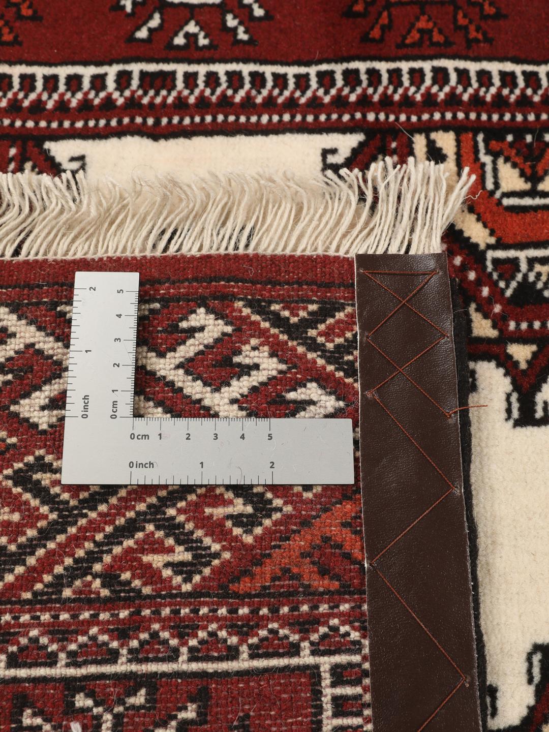 A long, hand-knotted Turkaman runner from the Middle East featuring a vibrant red and cream geometric design.