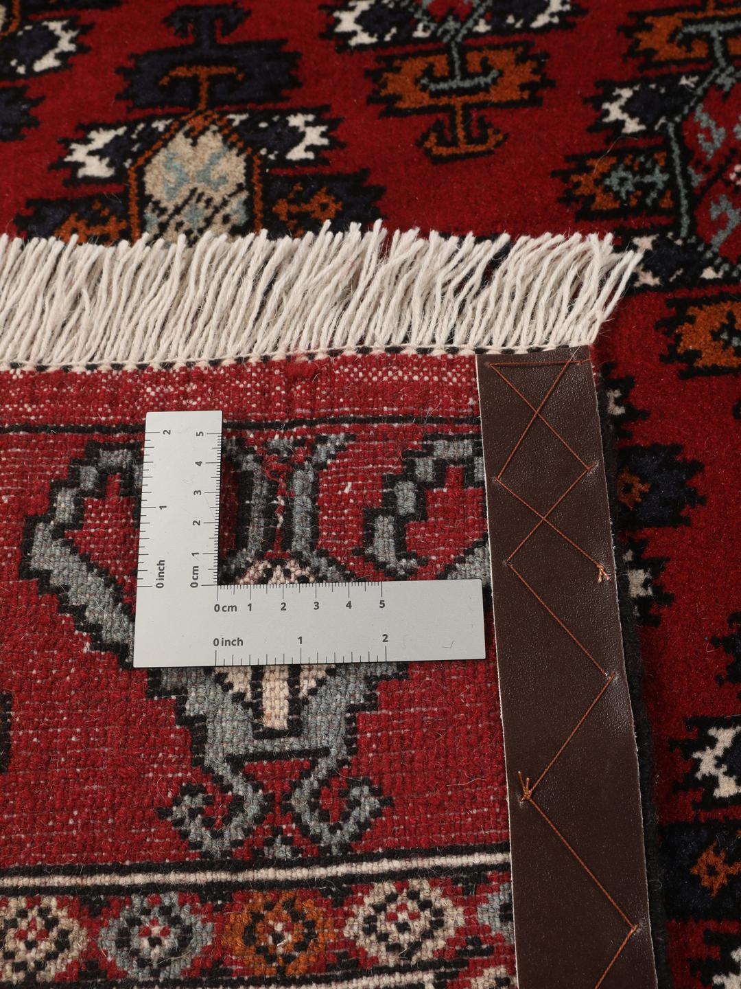 Hand-knotted Turkaman wool rug with a vibrant red field and tribal geometric patterns from the Middle East