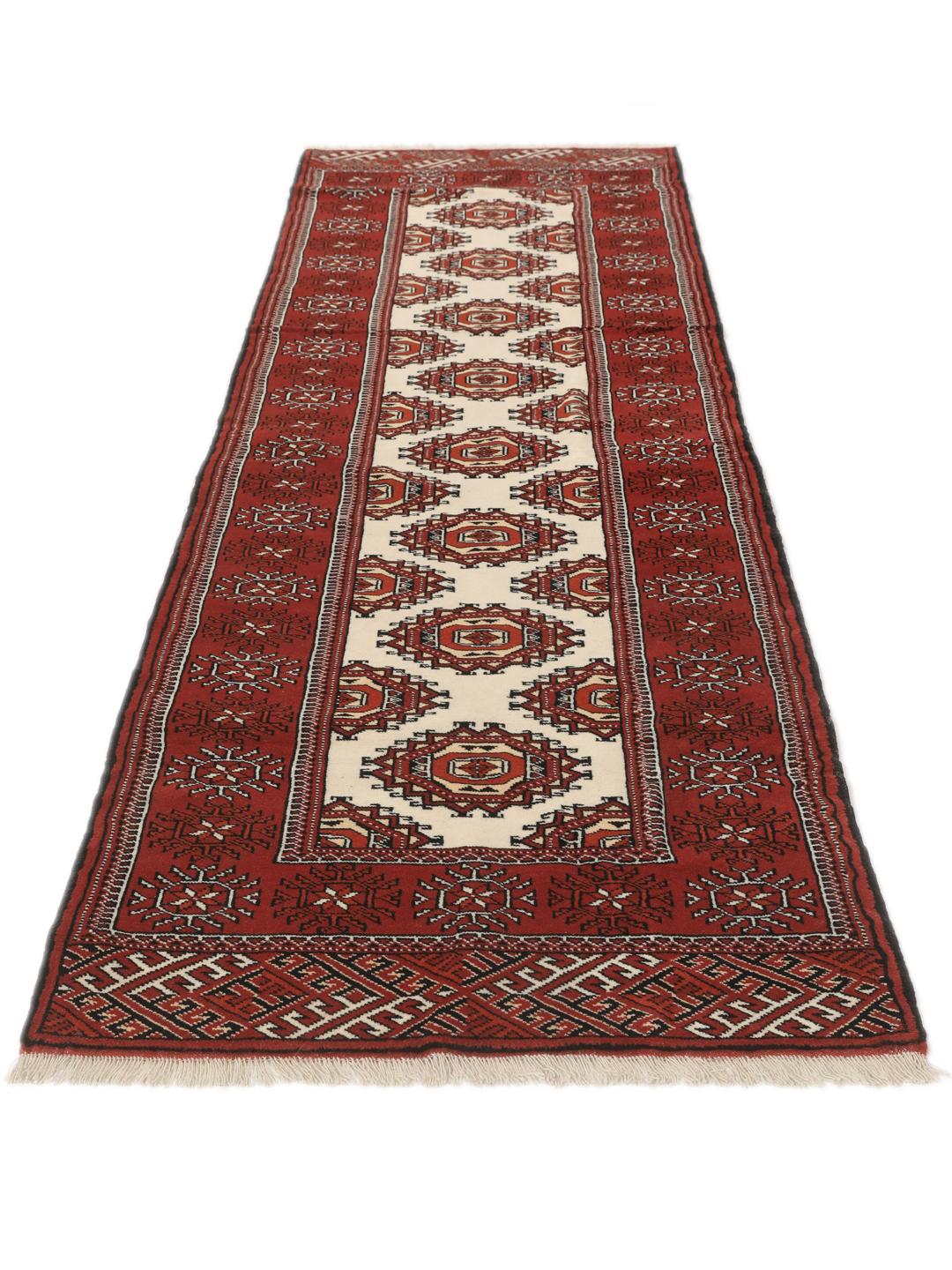 A hand-knotted red Turkaman runner with intricate geometric patterns.