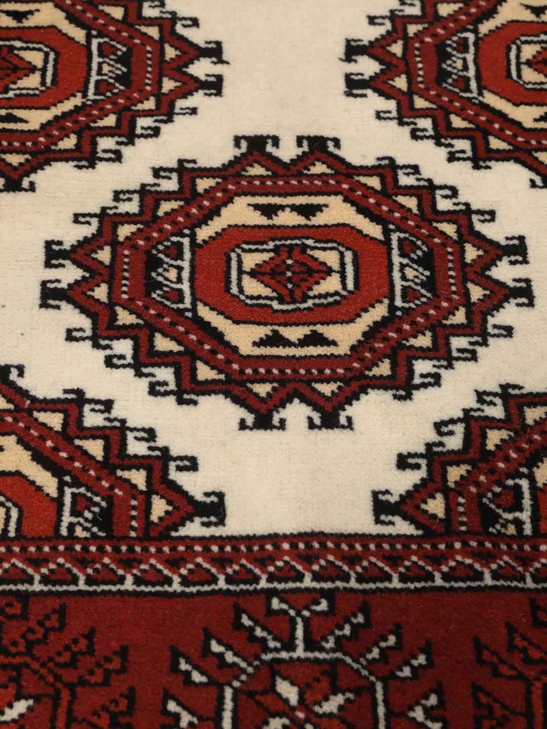 A hand-knotted red Turkaman runner with intricate geometric patterns.