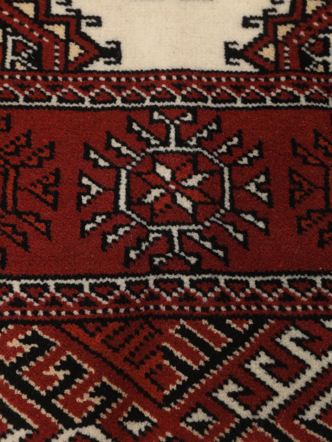 A hand-knotted red Turkaman runner with intricate geometric patterns.
