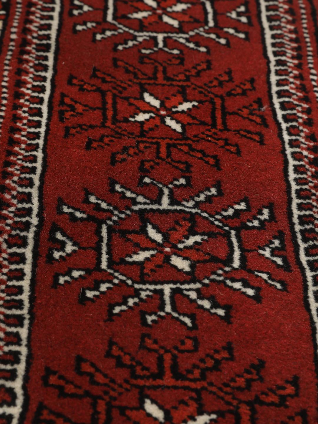 A hand-knotted red Turkaman runner with intricate geometric patterns.