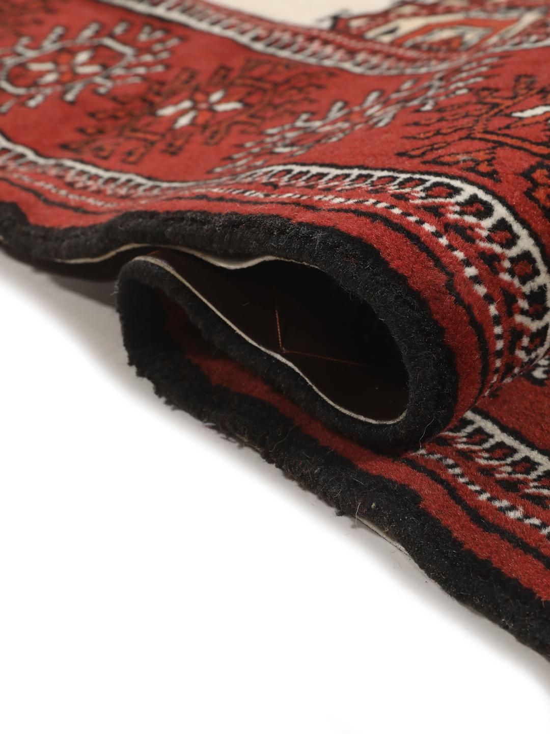A hand-knotted red Turkaman runner with intricate geometric patterns.