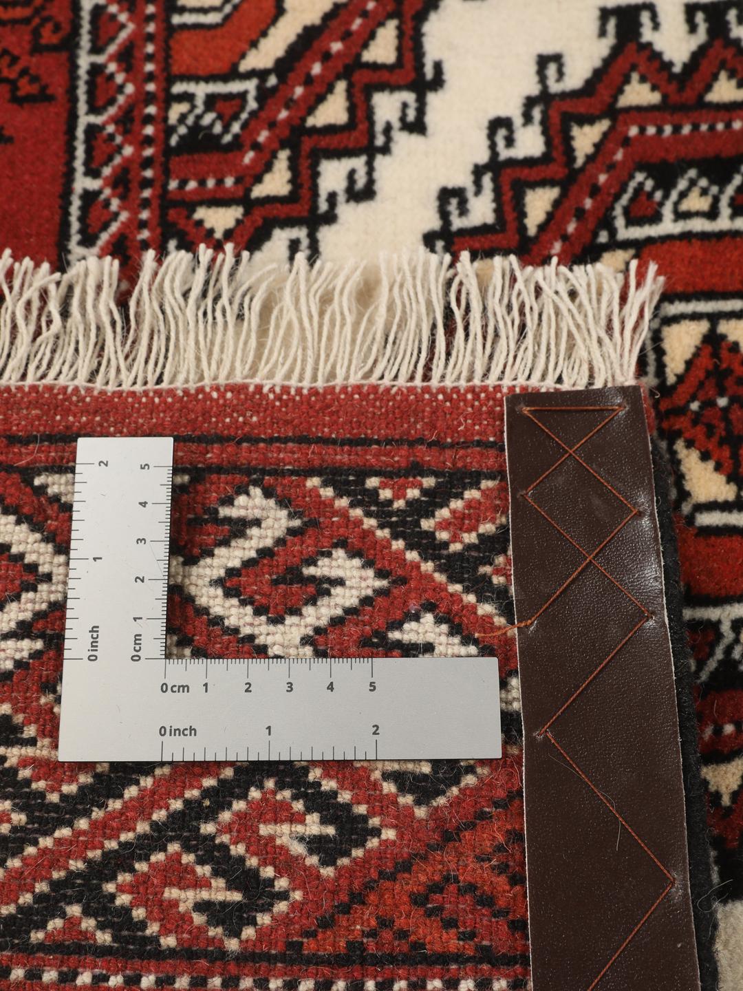 A hand-knotted red Turkaman runner with intricate geometric patterns.