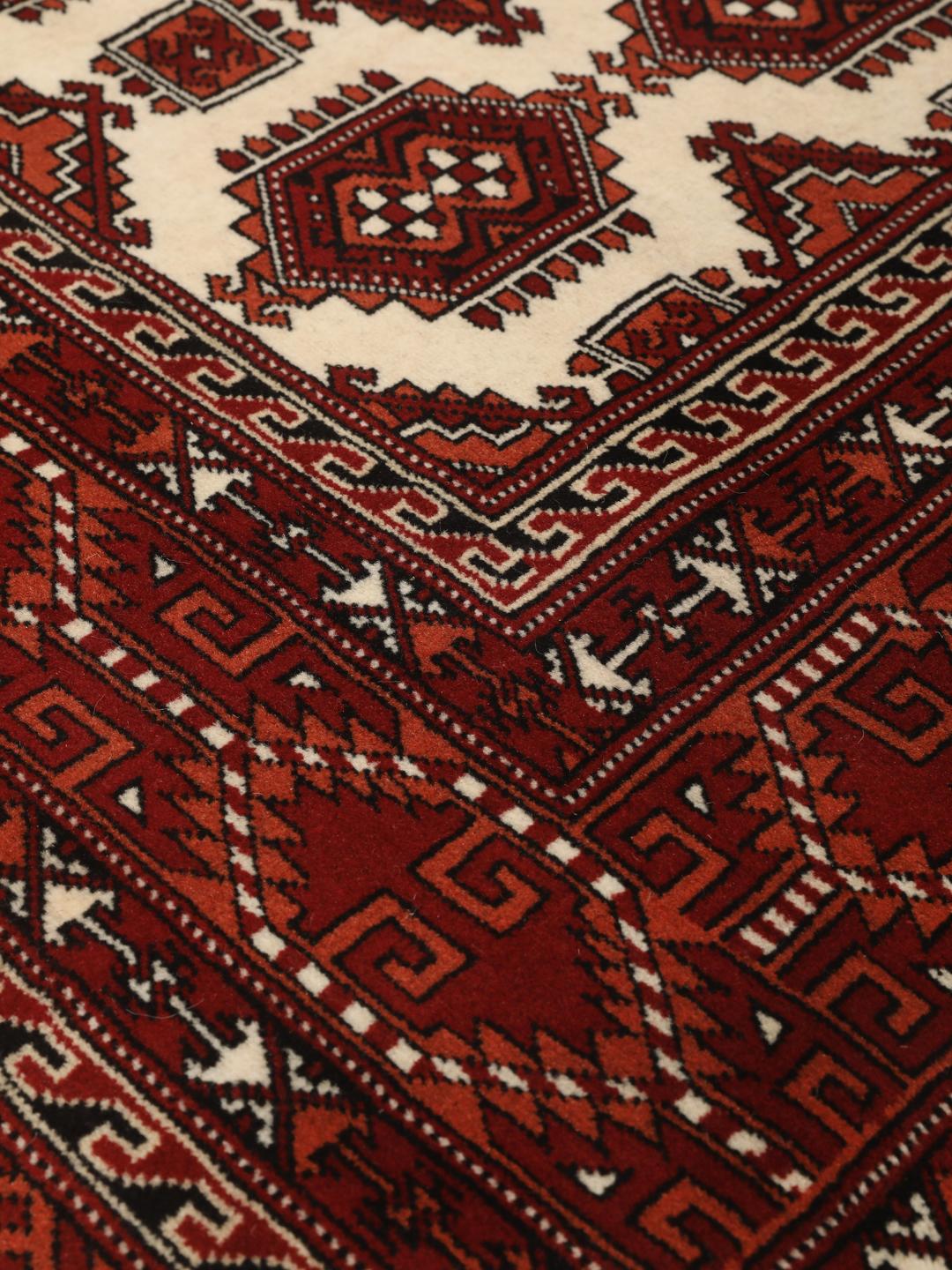 Hand-knotted Turkaman rug with a deep red field and geometric motifs