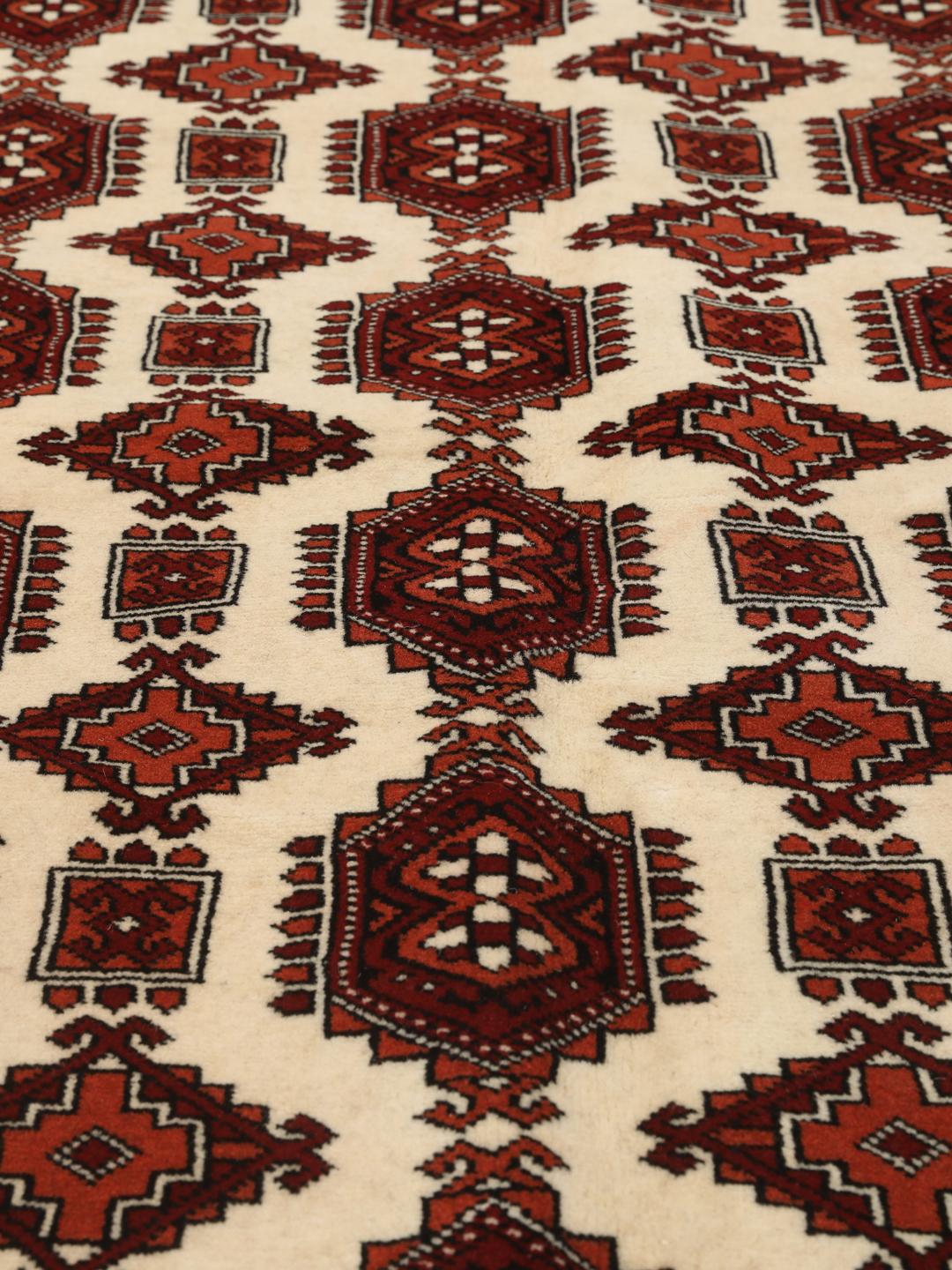 Hand-knotted Turkaman rug with a deep red field and geometric motifs