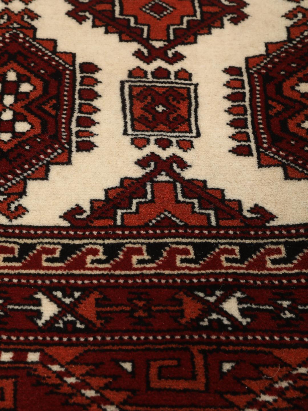 Hand-knotted Turkaman rug with a deep red field and geometric motifs