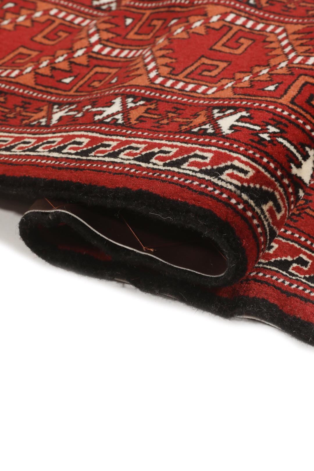 Hand-knotted Turkaman rug with a deep red field and geometric motifs