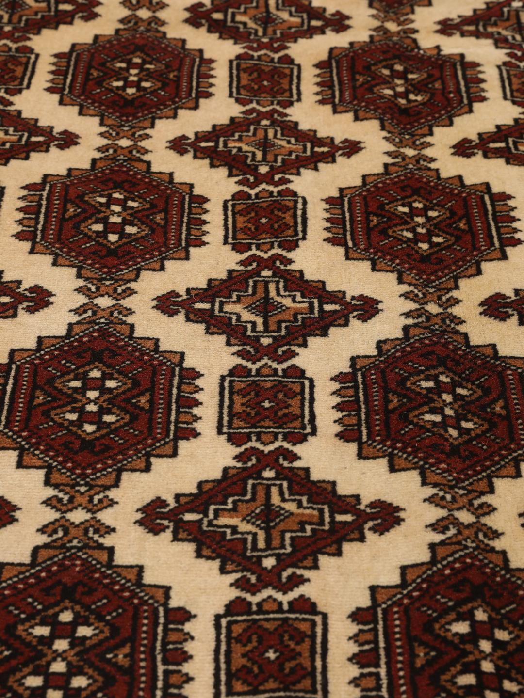 Hand-knotted Turkaman Wool rug with geometric patterns in red and beige from the Middle East.