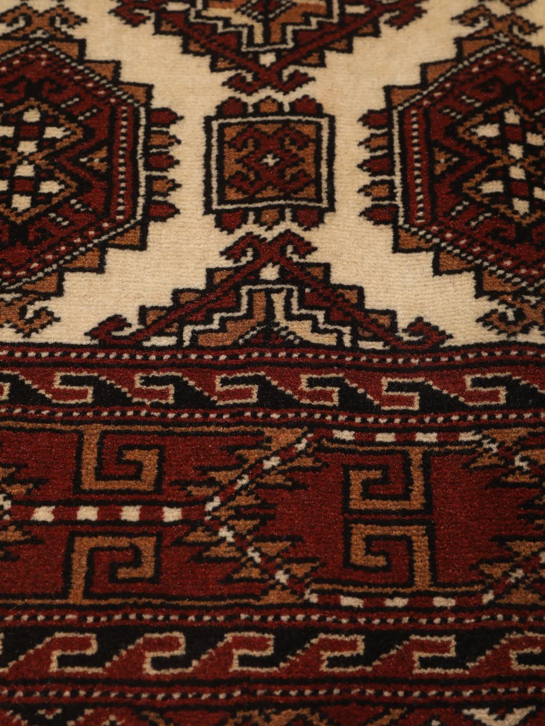 Hand-knotted Turkaman Wool rug with geometric patterns in red and beige from the Middle East.