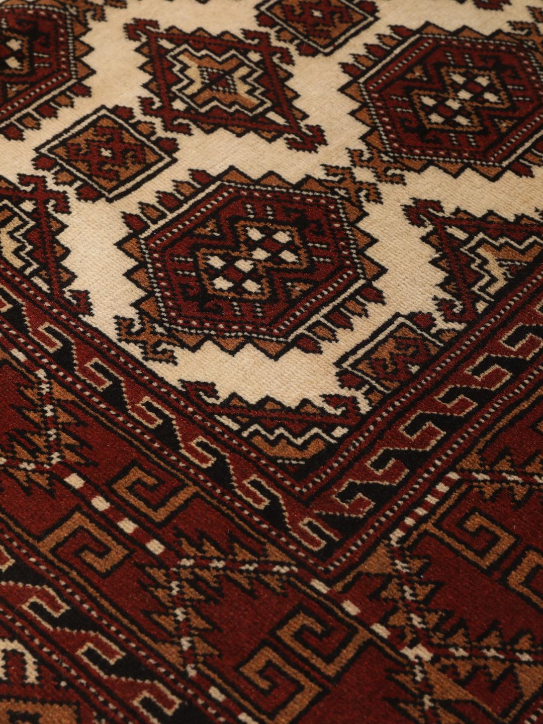Hand-knotted Turkaman Wool rug with geometric patterns in red and beige from the Middle East.