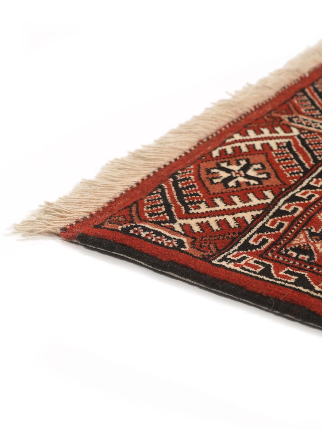 A hand-knotted, one-of-a-kind Turkaman rug with a red field and traditional geometric motifs.
