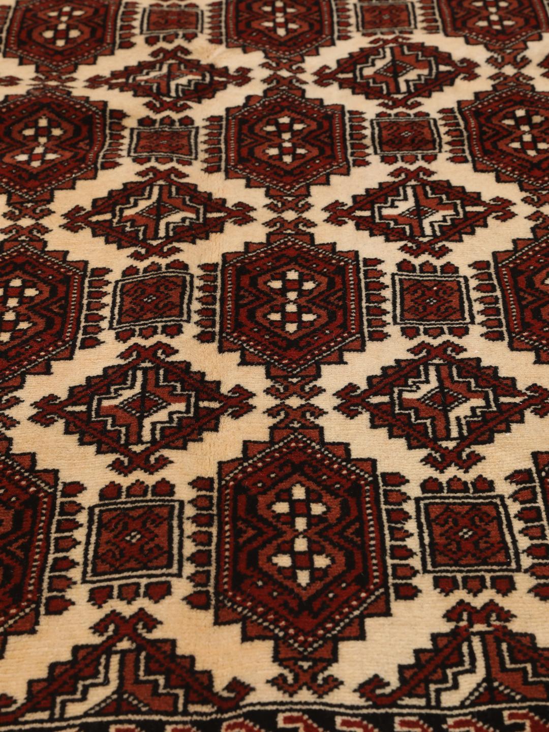 A hand-knotted, one-of-a-kind Turkaman rug with a red field and traditional geometric motifs.