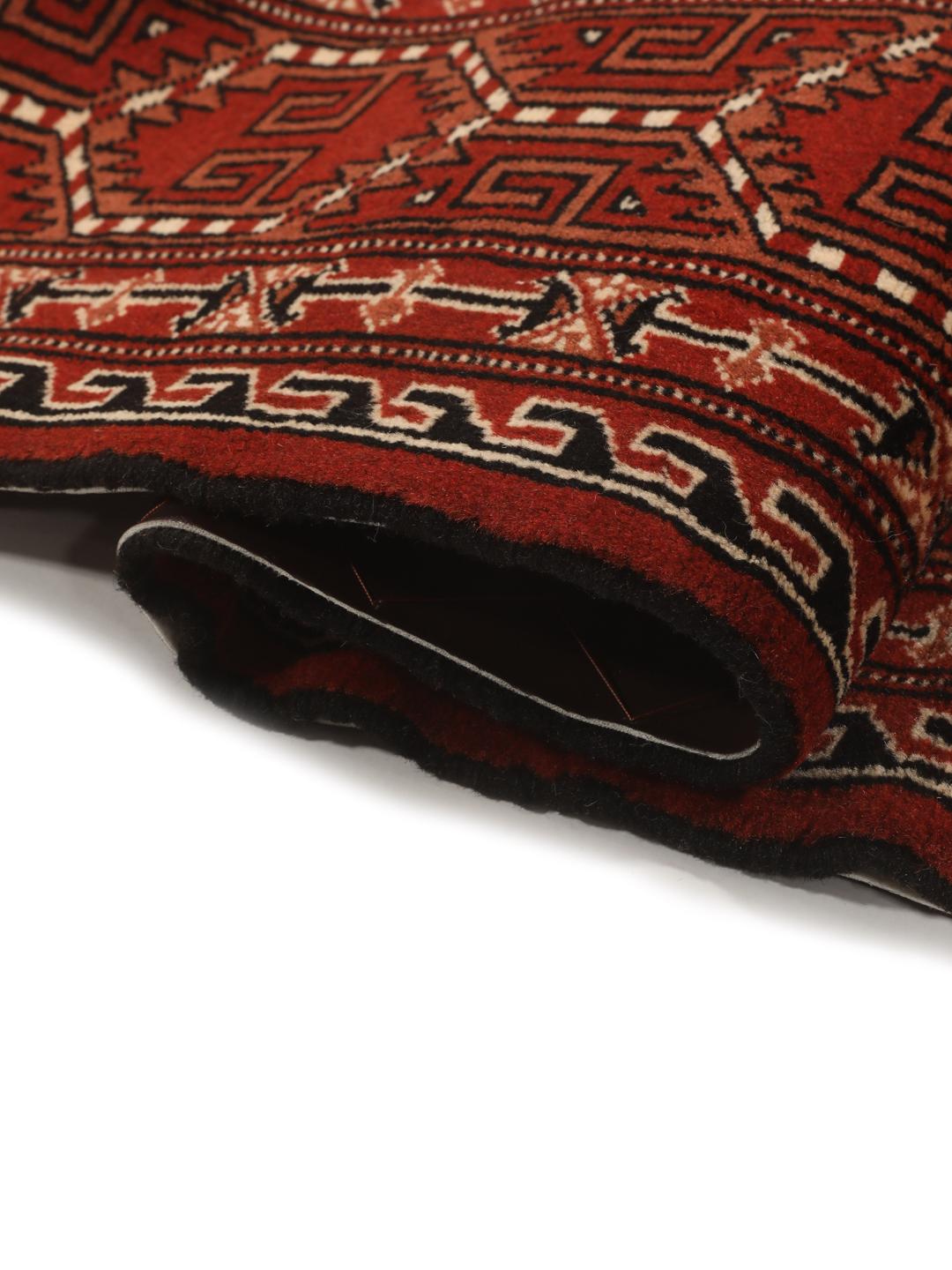 A hand-knotted, one-of-a-kind Turkaman rug with a red field and traditional geometric motifs.