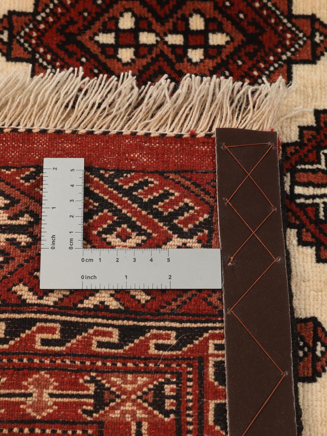 A hand-knotted, one-of-a-kind Turkaman rug with a red field and traditional geometric motifs.