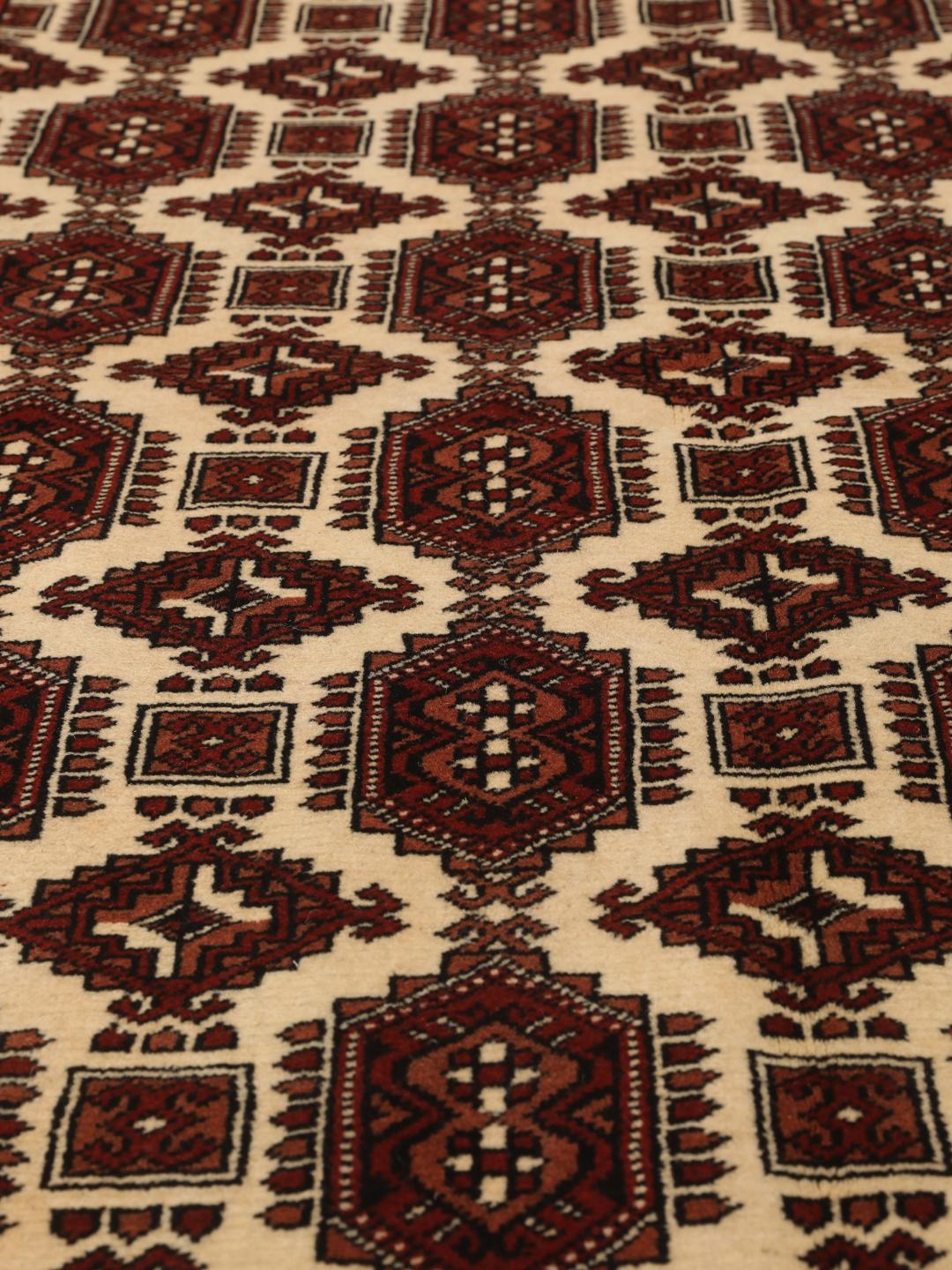 Hand-knotted Turkaman rug from the Middle East in deep red and cream tones.