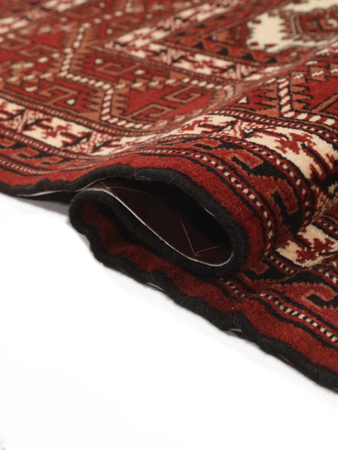 Hand-knotted Turkaman rug from the Middle East in deep red and cream tones.