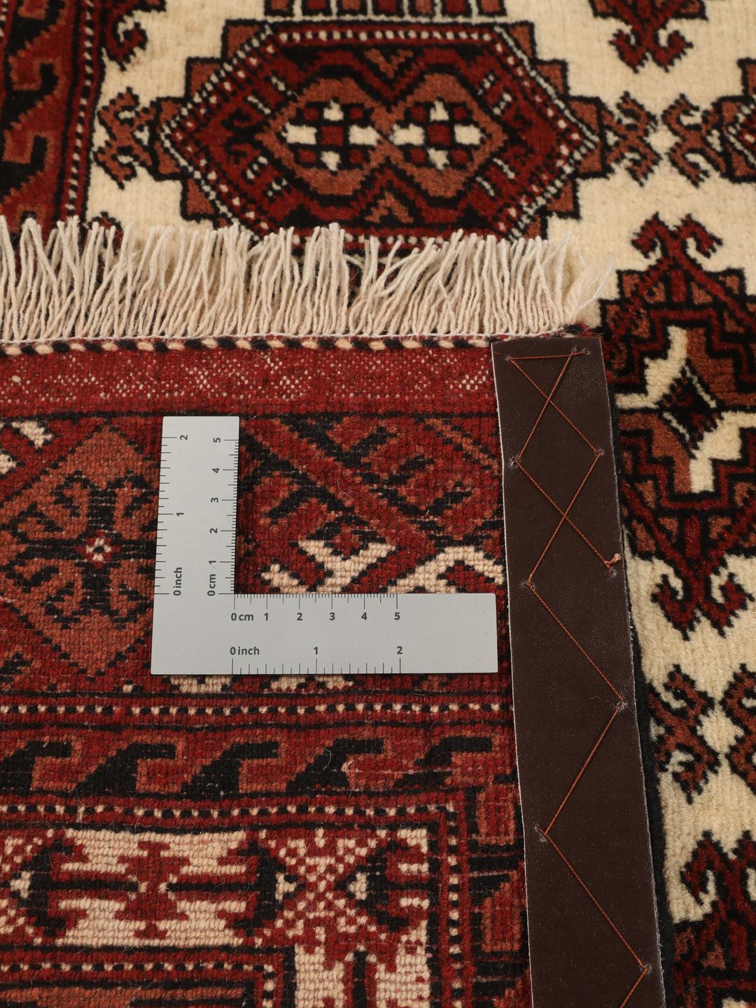 Hand-knotted Turkaman rug from the Middle East in deep red and cream tones.