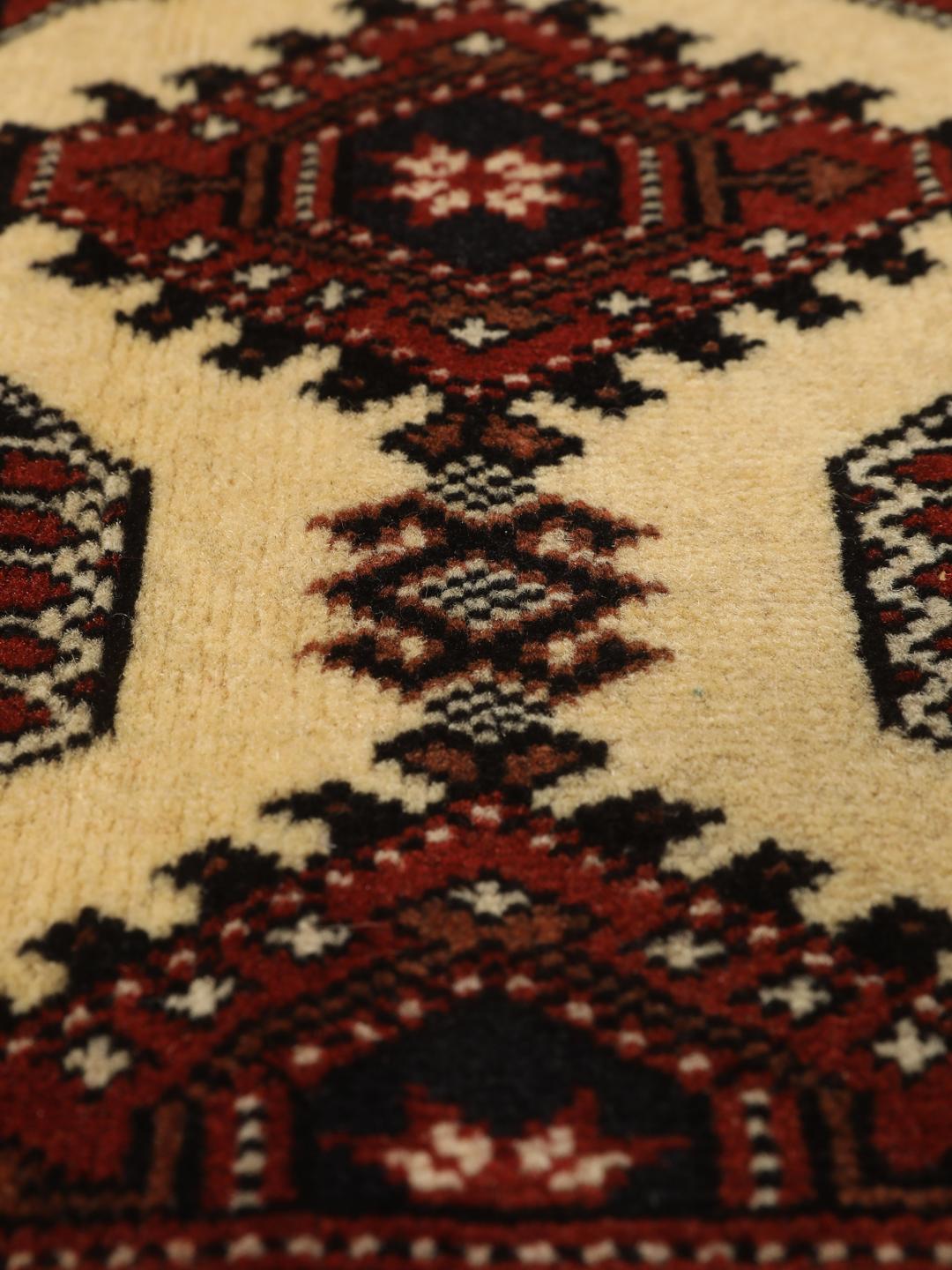 Hand-knotted Turkaman rug from the Middle East in deep red and beige tones.