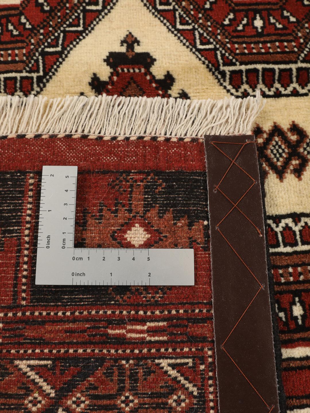 Hand-knotted Turkaman rug from the Middle East in deep red and beige tones.