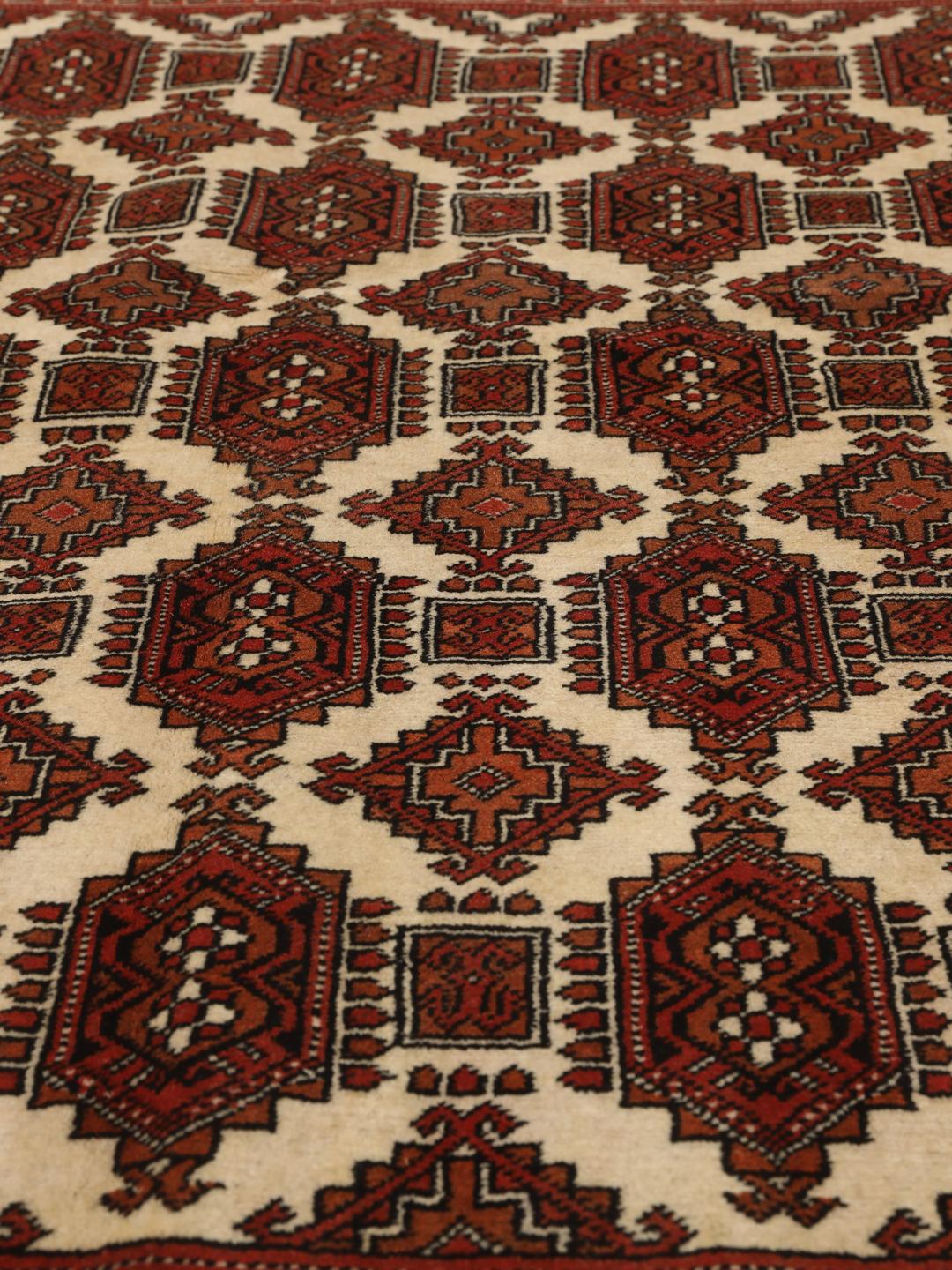 Hand-knotted Turkaman rug from the Middle East in red and beige tones.