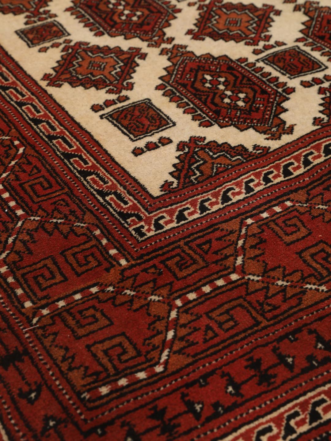 Hand-knotted Turkaman rug from the Middle East in red and beige tones.