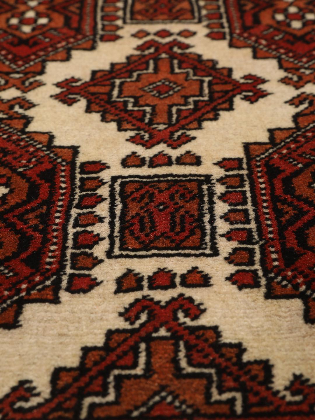 Hand-knotted Turkaman rug from the Middle East in red and beige tones.