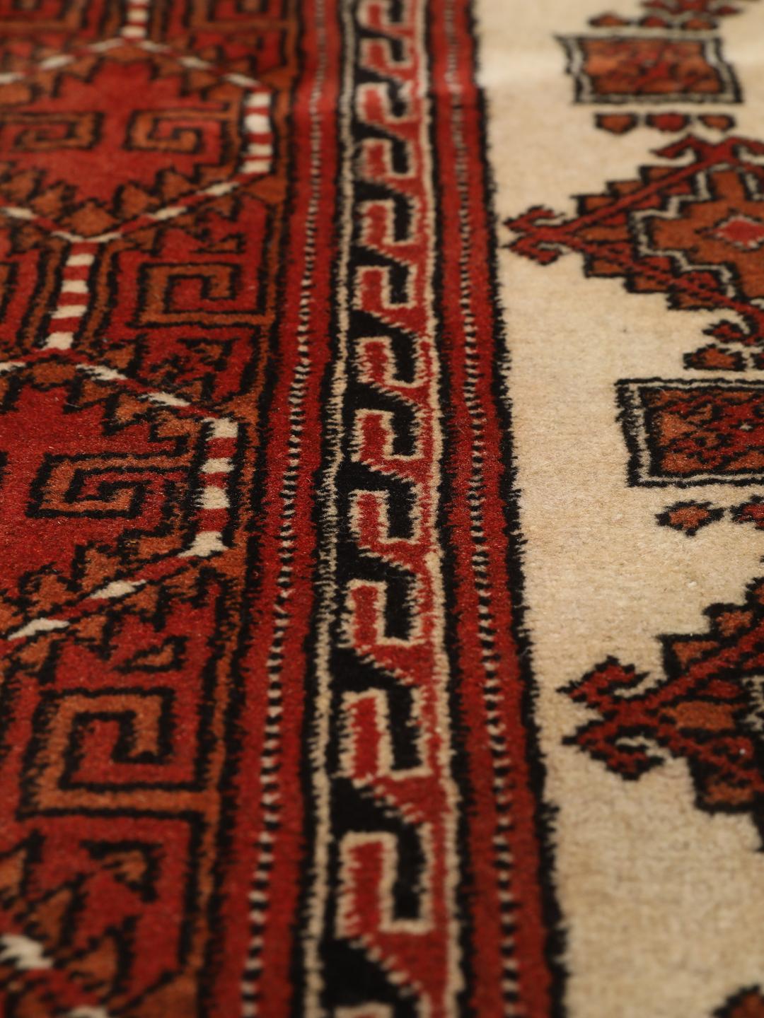 Hand-knotted Turkaman rug from the Middle East in red and beige tones.
