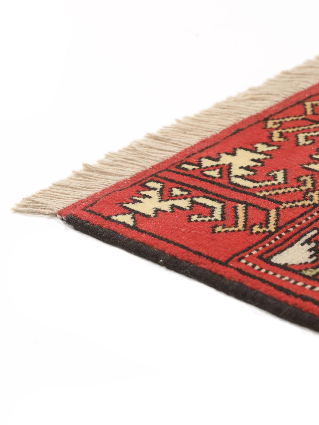 A hand-knotted Turkaman rug from the Middle East with a red base and geometric patterns.