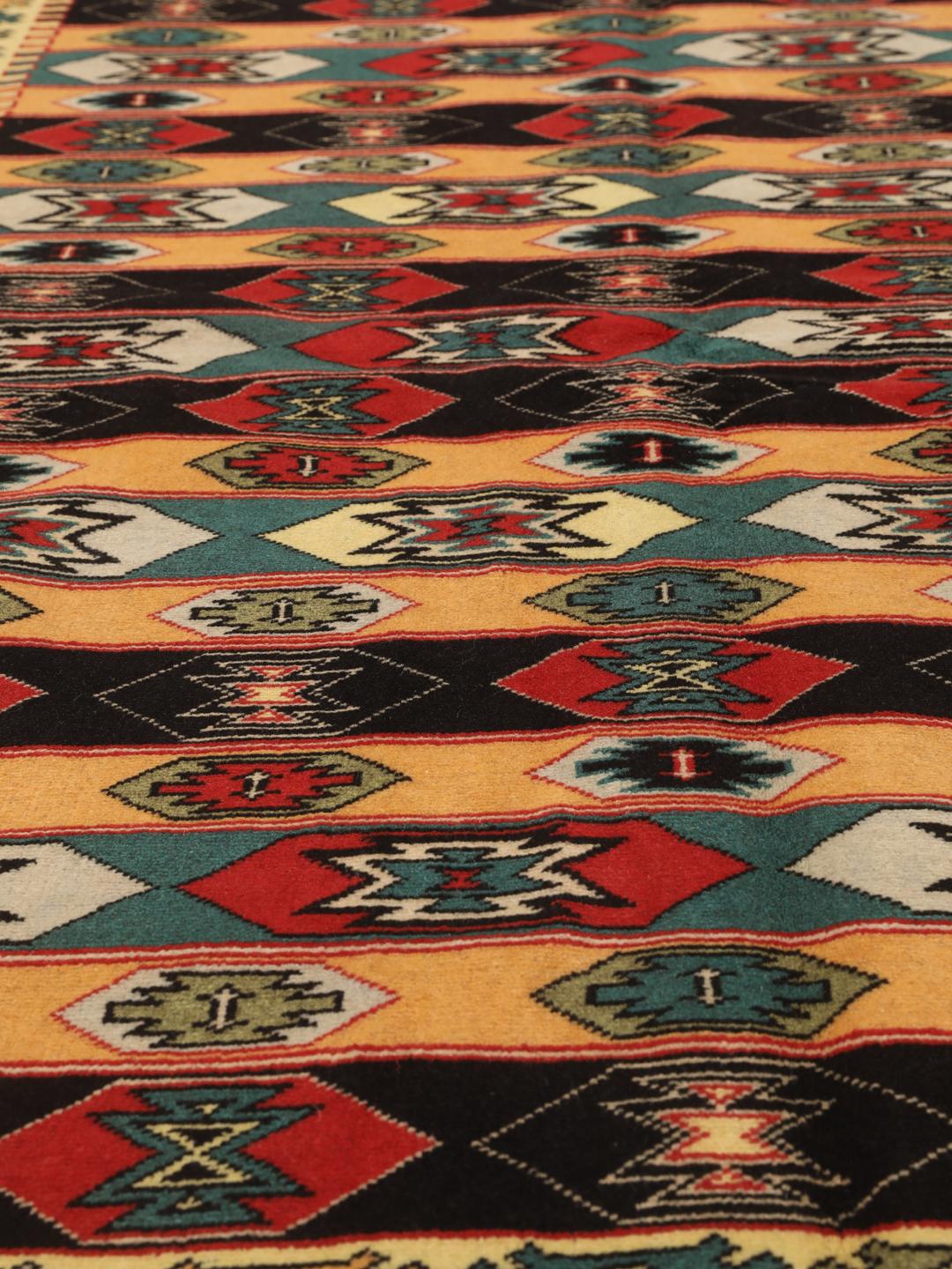 A hand-knotted Turkaman rug from the Middle East with a red base and geometric patterns.
