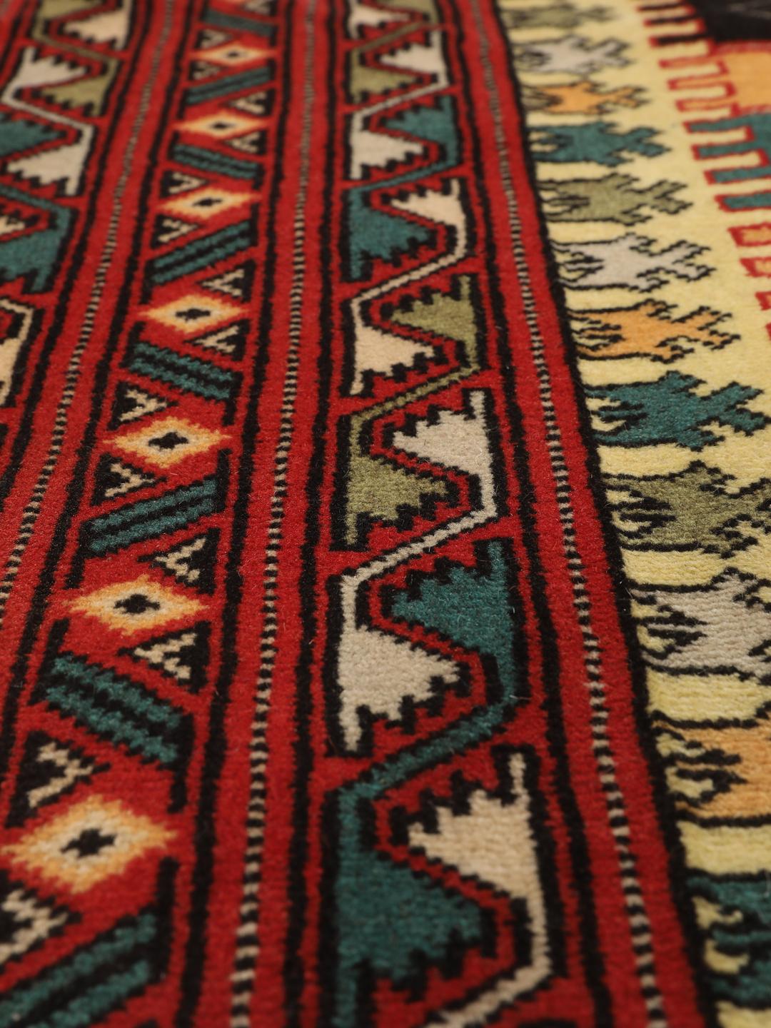 A hand-knotted Turkaman rug from the Middle East with a red base and geometric patterns.