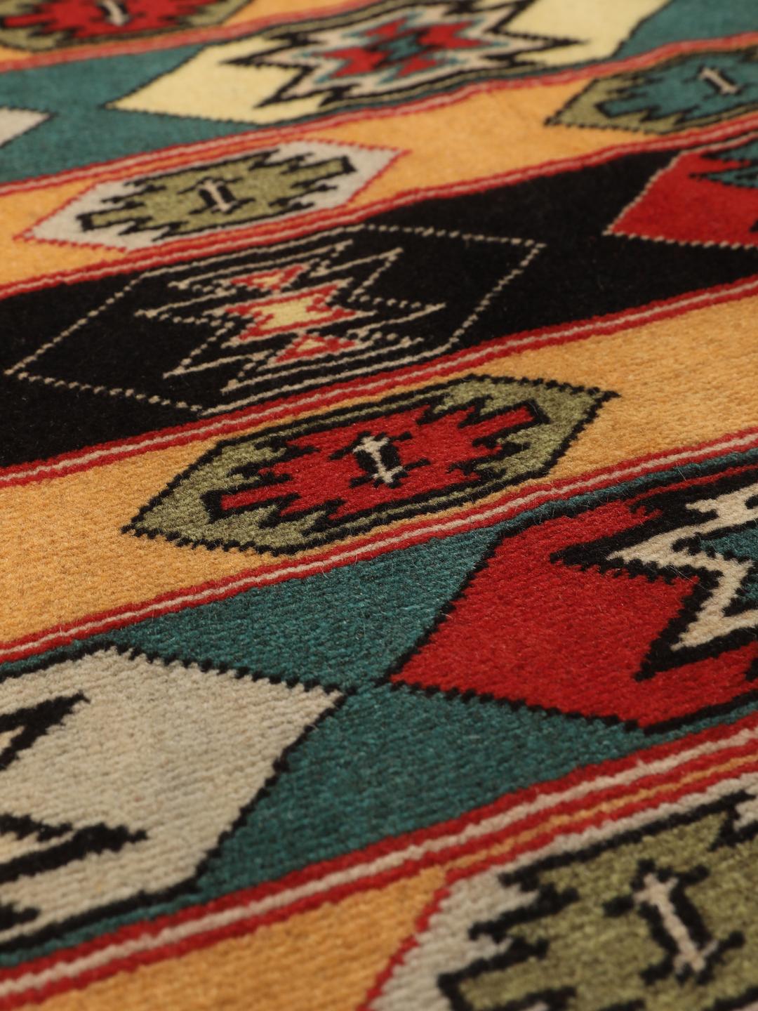 A hand-knotted Turkaman rug from the Middle East with a red base and geometric patterns.