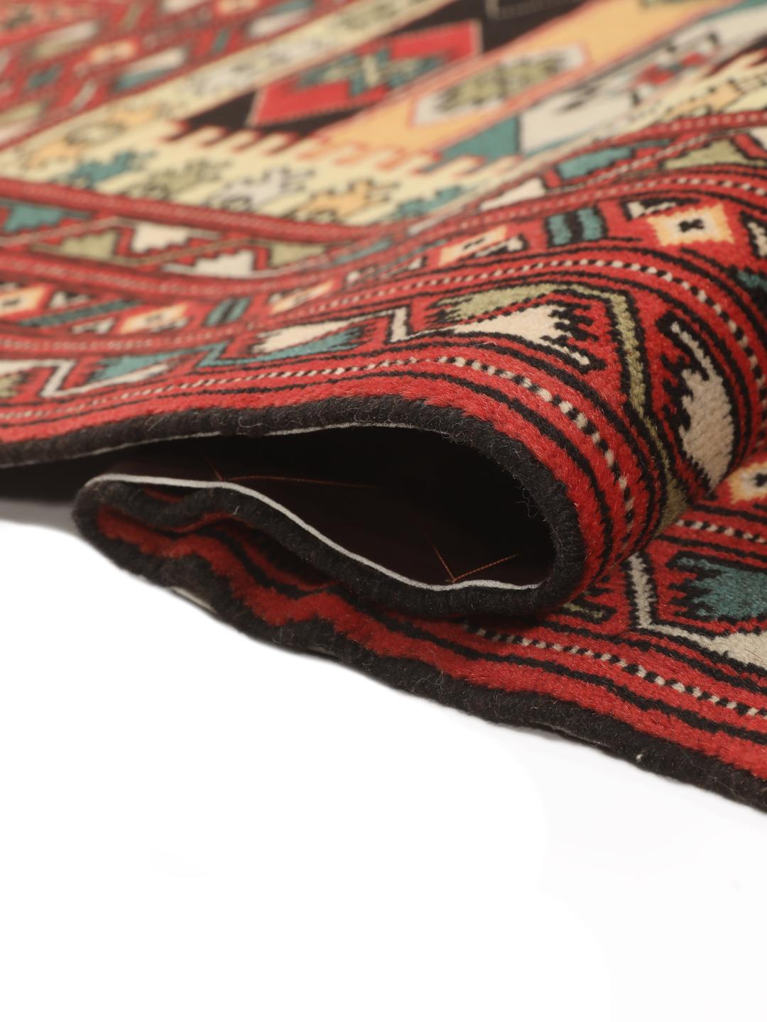 A hand-knotted Turkaman rug from the Middle East with a red base and geometric patterns.