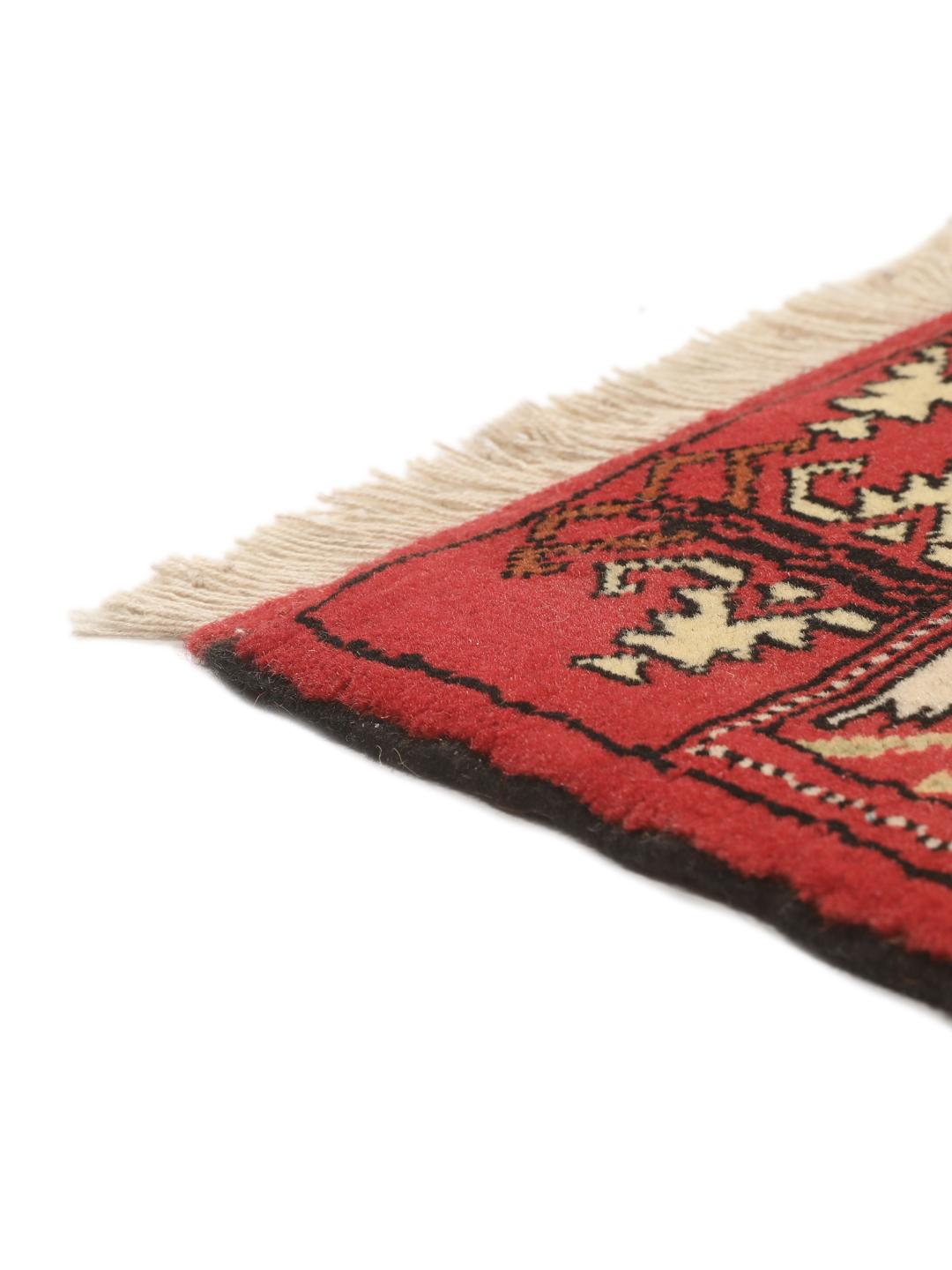 A hand-knotted Turkaman rug from the Middle East with a vibrant red and multicoloured geometric design.