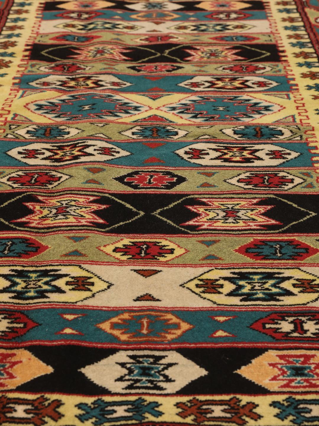 A hand-knotted Turkaman rug from the Middle East with a vibrant red and multicoloured geometric design.