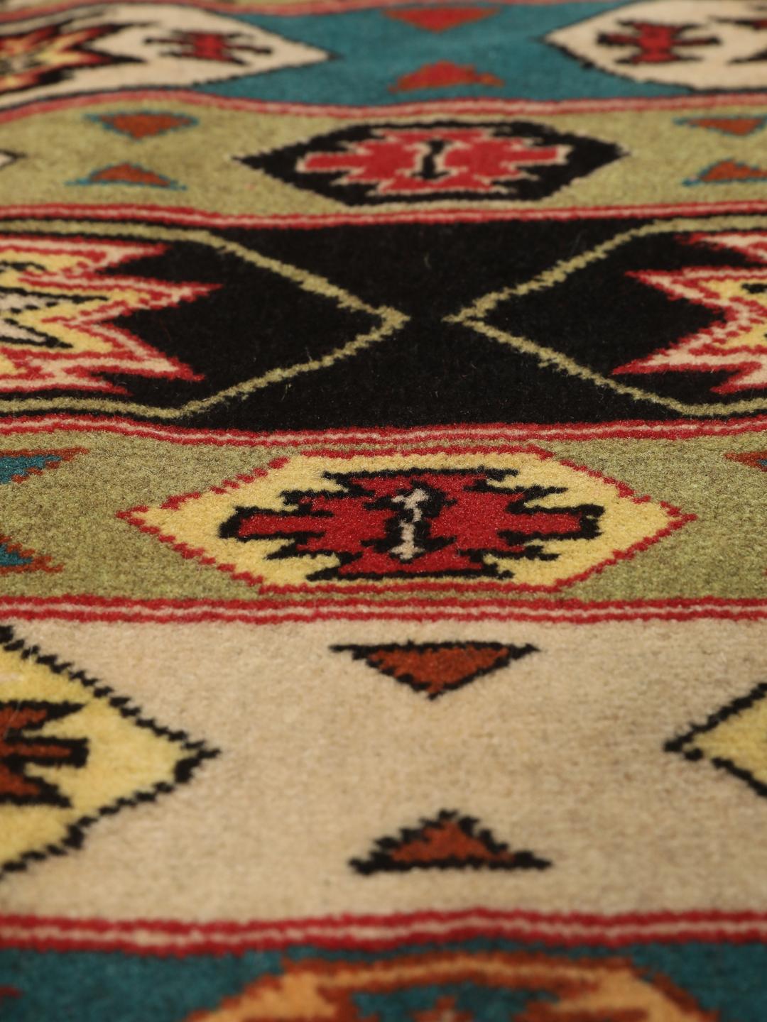 A hand-knotted Turkaman rug from the Middle East with a vibrant red and multicoloured geometric design.