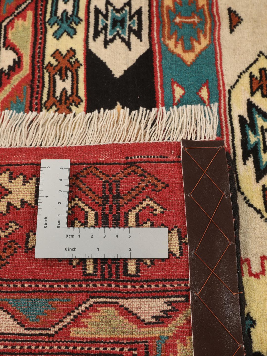 A hand-knotted Turkaman rug from the Middle East with a vibrant red and multicoloured geometric design.