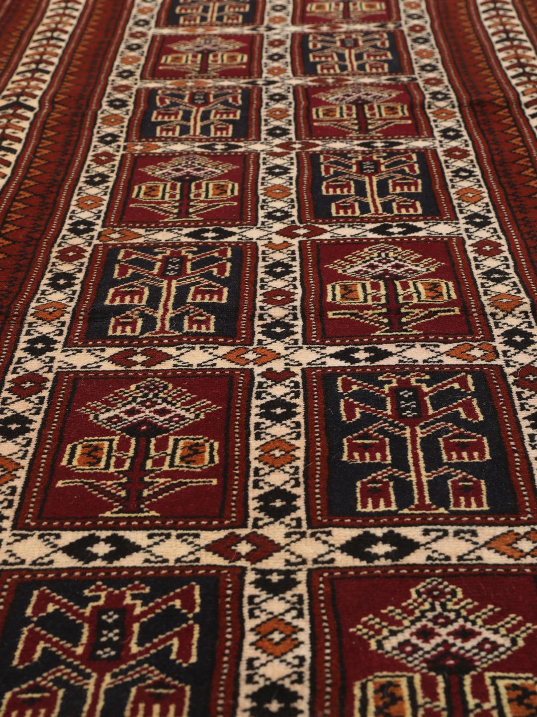A hand-knotted Turkaman runner from the Middle East featuring a dark-red field with geometric motifs.