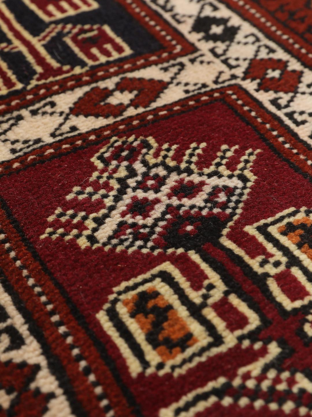 A hand-knotted Turkaman runner from the Middle East featuring a dark-red field with geometric motifs.